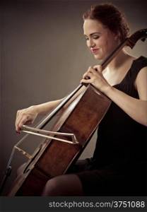 Photo of a beautiful woman playing an old cello.