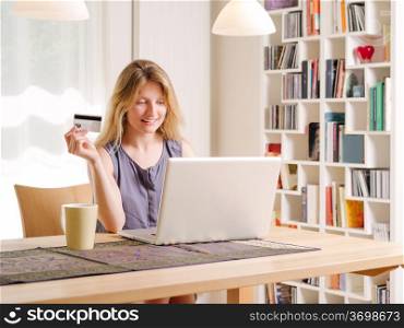 Photo of a beautiful young female shopping online and paying with a credit card. Credit card information is fictitious.