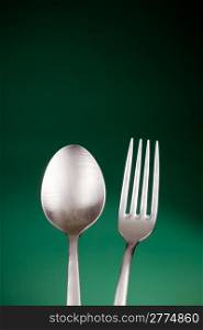 photo of a fork and a spoon in front of a colorful background