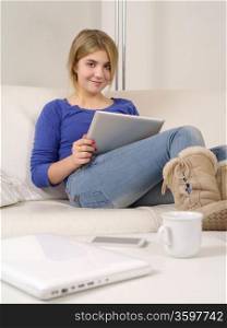 Photo of a happy young teenage female using a computer tablet at home.&#xA;