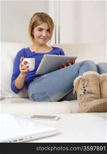 Photo of a happy young teenage female using a computer tablet at home.&#xA;