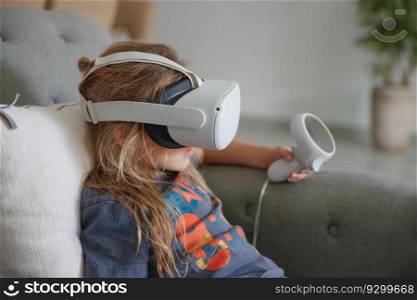 Photo of a little boy playing video game at home. Modern technology. Simulation of a virtual reality. Clever kid enjoying cyberspace. VR mask. Baby boy play in virtual reality