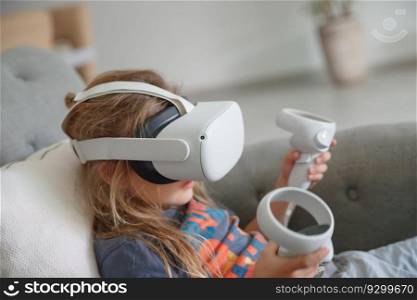 Photo of a little boy wearing VR mask playing video game at home. Simulation of a virtual reality. Smart child enjoy cyberspace. Online competition.. Active child playing video game at home