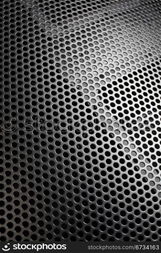 Photo of a loudspeaker grill as a background. Selective focus through the middle.