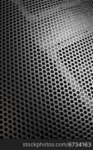 Photo of a loudspeaker grill as a background. Selective focus through the middle.