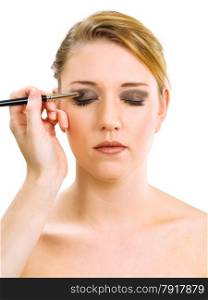 Photo of a makeup artist applying eye makeup onto a blond model.&#xA;