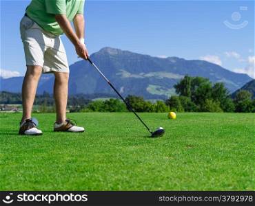 Photo of a male golfer about to tee off on the golf course.&#xA;