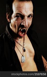 Photo of a male vampire with mouth open and fangs showing. Harsh lighting and heavily filtered for scarier feel.
