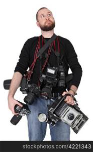 Photo of a man in his late twenties, standing and holding many cameras, film, digital, medium format and large format.