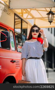 Photo of a perky beauty on the background of a red food truck with coffee.. A perky beautys walk through the summer streets of Arzamas 4189.