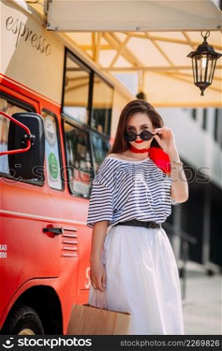 Photo of a perky beauty on the background of a red food truck with coffee.. A perky beautys walk through the summer streets of Arzamas 4190.