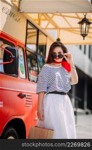 Photo of a perky beauty on the background of a red food truck with coffee.. A perky beautys walk through the summer streets of Arzamas 4190.