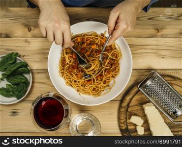 Photo of a plate of traditional spaghetti bolognese and glass of red wine from above.