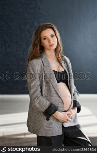 Photo of a pregnant girl in a photo studio.. A pregnant girl with a bare big belly 4114.