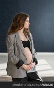 Photo of a pregnant girl in a photo studio.. A pregnant girl with a bare big belly 4115.