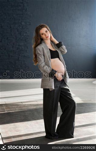 Photo of a pregnant girl in a photo studio.. A pregnant girl with a bare big belly 4112.