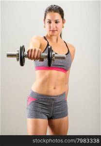 Photo of a pretty woman doing shoulder exercises with a dumbbell.&#xA;