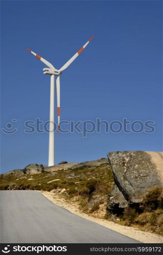 photo of a road with wind turbine on the mountain