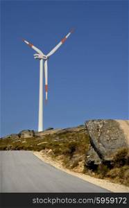 photo of a road with wind turbine on the mountain