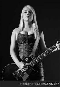 Photo of a sexy blond female playing a black electric guitar.