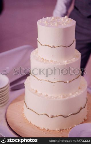 Photo of a wedding cake in three tiers high.. A beige wedding cake three tiers high 3787.