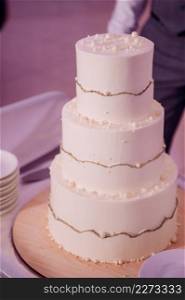 Photo of a wedding cake in three tiers high.. A beige wedding cake three tiers high 3787.