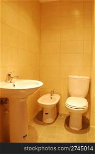 photo of a white and small bathroom interior (golden tiles)