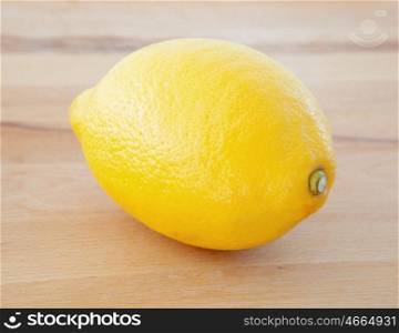 Photo of a yellow lemon on a wooden table