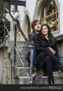 Photo of a young couple sitting and resting in an old town in Europe.&#xA;