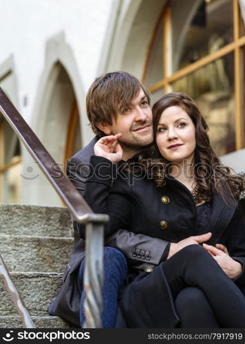 Photo of a young couple sitting and resting in an old town in Europe.&#xA;