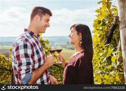 Photo of a young couple tasting and drinking wine in a vineyard.&#xA;