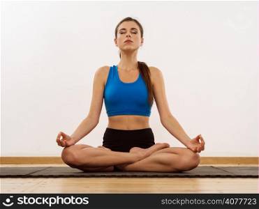 Photo of a young woman in her twenties doing yoga and the lotus position.&#xA;