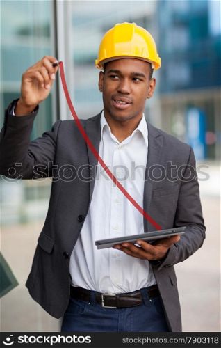 Photo of African construction engineer drawing with a digital pen