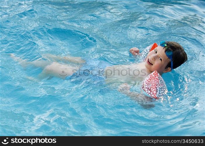 photo of an adorable boy learning to swim