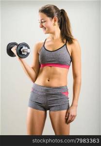 Photo of an attractive woman doing a dumbbell curl while standing.&#xA;