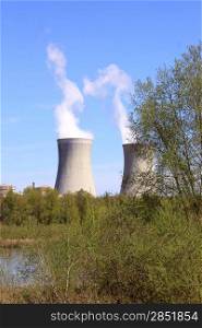 photo of an operating nuclear power plant on the banks of a river surrounded by trees