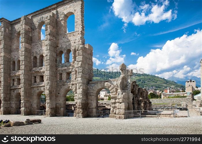 photo of ancient theater in aosta in front of a cloudy blue sky