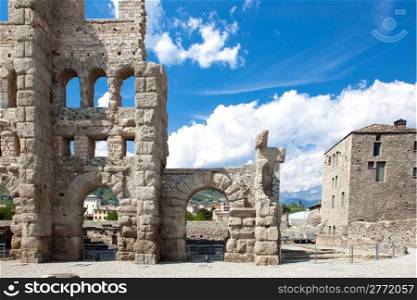 photo of ancient theater in aosta in front of a cloudy blue sky