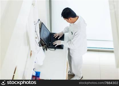 photo of asian dentist working on a computer in his office