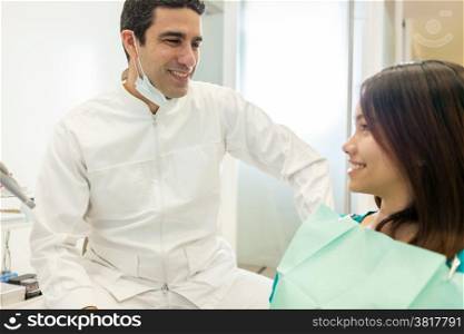 photo of asian male dentist speaking with his female patient in the office