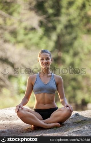 Photo of Attractive blonde woman is relaxing while sitting on the rock