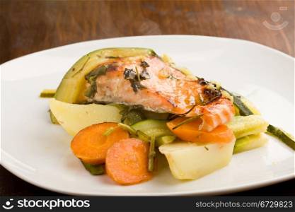 photo of baked salmon with vegetables on white plate