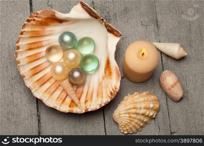 Photo of bath pearls in a shell over wooden table