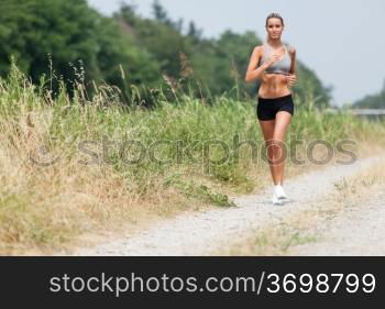 Photo of beautiful blonde woman running along the riverside