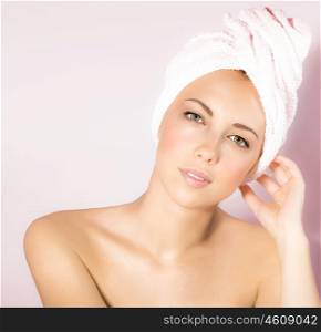 Photo of beautiful girl in spa salon, closeup portrait of attractive woman isolated on pink background, cute female enjoying dayspa, young pretty lady with bath towel on head, beauty treatment&#xA;&#xA;