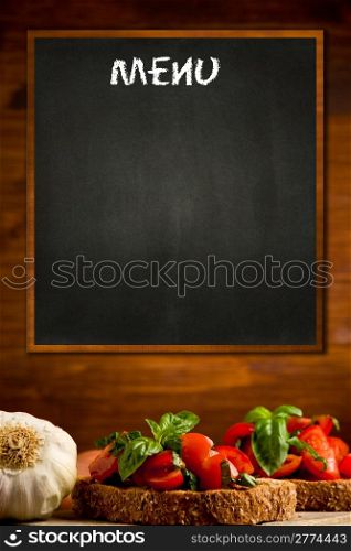 photo of blackboard with bruschetta appetizer background on wooden wall