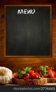 photo of blackboard with bruschetta appetizer background on wooden wall