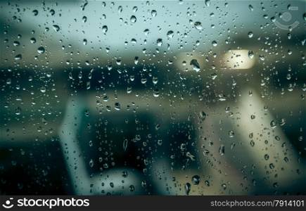 Photo of blurred building through window with raindrops