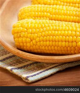 Photo of boiled sweetcorn on the plate in kitchen, tasty healthy cusine, prepared corn with salt, vegetarian meal, organic food, cooked cob of fresh yellow maize, cooking vegetable