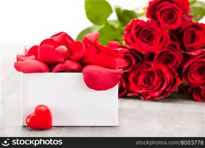 Photo of bouquet of red roses and gift box
